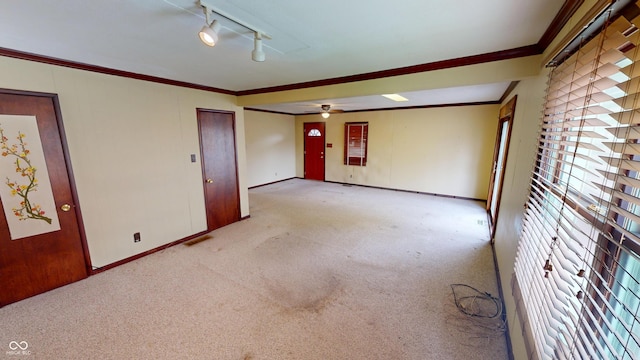 unfurnished room with baseboards, ornamental molding, carpet, and a ceiling fan