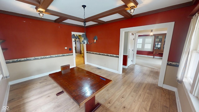 unfurnished dining area with baseboards, wood finished floors, beamed ceiling, ornamental molding, and coffered ceiling