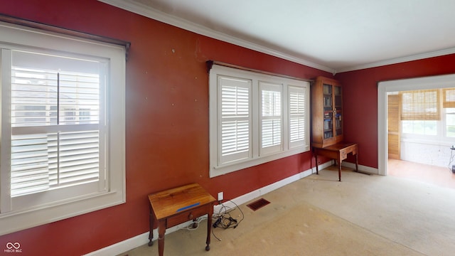 interior space with baseboards, visible vents, and ornamental molding