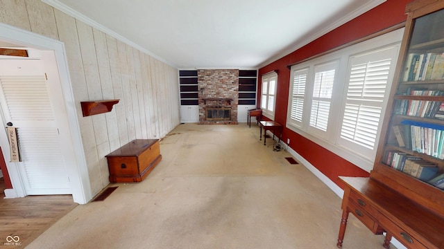 interior space with ornamental molding, a brick fireplace, wood walls, and carpet flooring