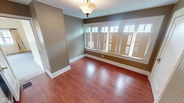 unfurnished dining area featuring baseboards, wood finished floors, and visible vents