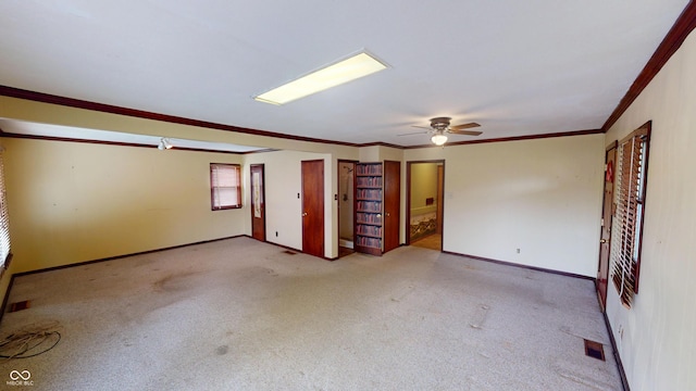carpeted spare room featuring baseboards, ornamental molding, and ceiling fan