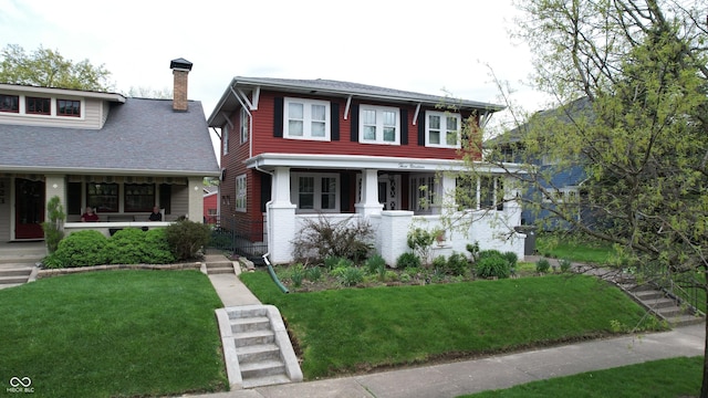 traditional style home with a porch, a shingled roof, a front lawn, and a chimney