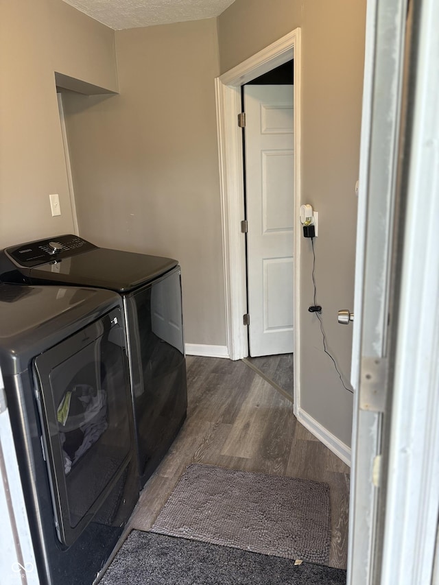 laundry room with separate washer and dryer, baseboards, laundry area, and dark wood finished floors
