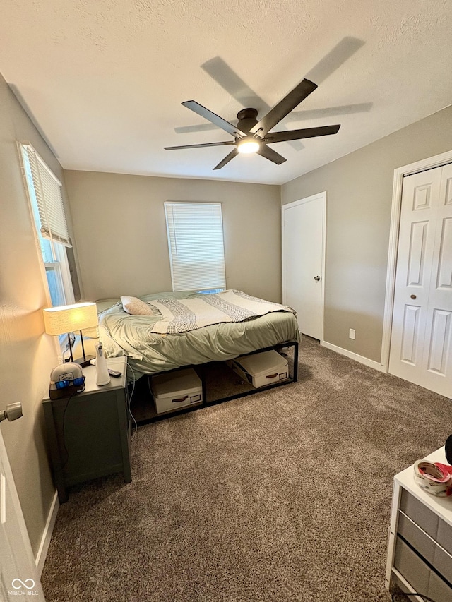 carpeted bedroom with baseboards, a ceiling fan, a textured ceiling, and multiple windows