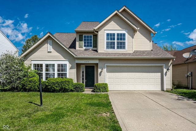 traditional-style house featuring roof with shingles, concrete driveway, a front lawn, and a garage