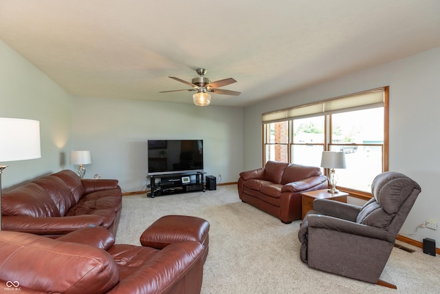 carpeted living area featuring baseboards and a ceiling fan