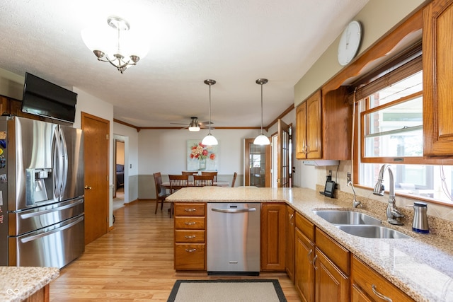 kitchen featuring ceiling fan, brown cabinetry, stainless steel refrigerator with ice dispenser, a sink, and a peninsula