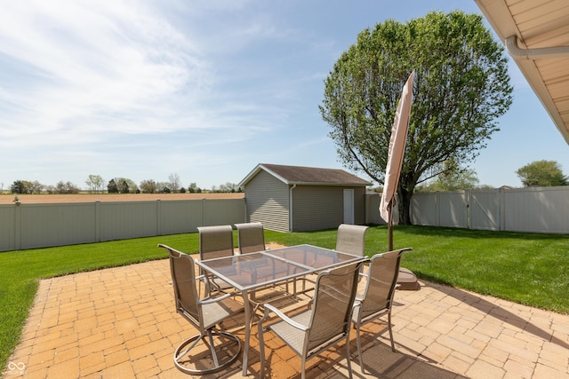 view of patio with outdoor dining area, a fenced backyard, a shed, and an outbuilding
