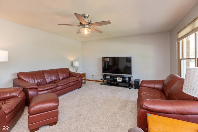 carpeted living area featuring baseboards and ceiling fan