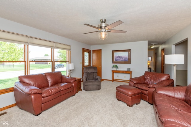 carpeted living room featuring baseboards and a ceiling fan