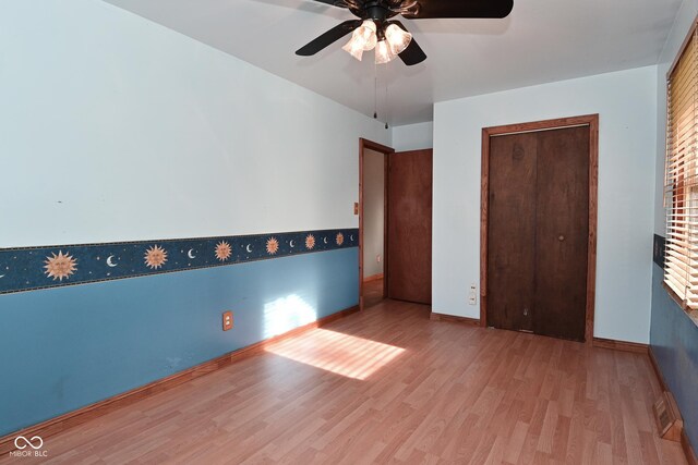 unfurnished bedroom with baseboards, ceiling fan, a closet, and wood finished floors