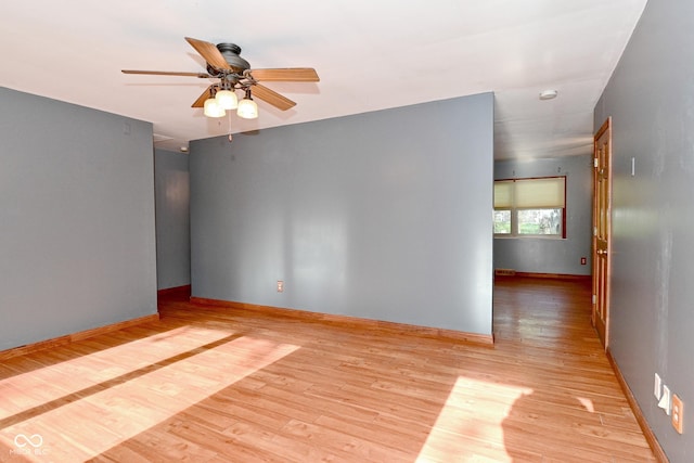 unfurnished room with baseboards, a ceiling fan, and wood finished floors