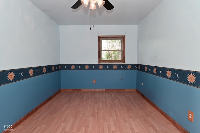 spare room with baseboards, ceiling fan, and wood finished floors