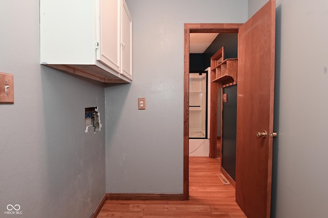 hall featuring baseboards and light wood finished floors