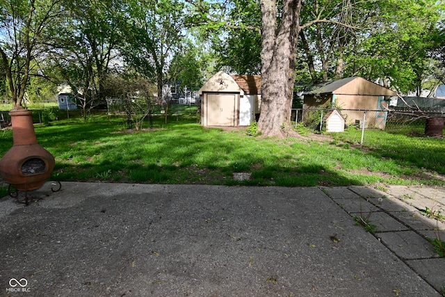 view of yard with a shed, an outbuilding, and fence