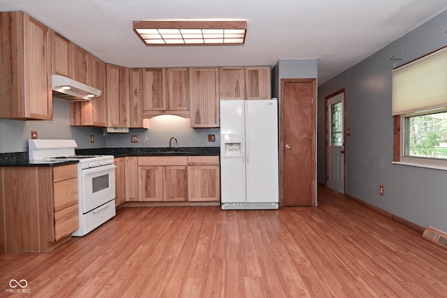 kitchen with visible vents, white appliances, under cabinet range hood, a sink, and light wood-style flooring