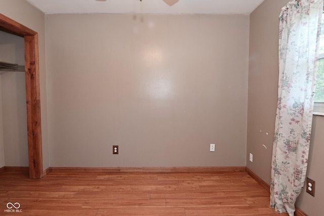 unfurnished bedroom featuring a ceiling fan, baseboards, and light wood-style flooring