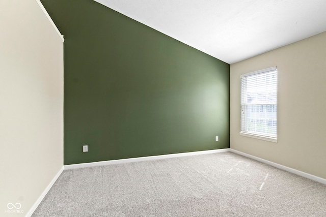 spare room featuring carpet flooring and baseboards