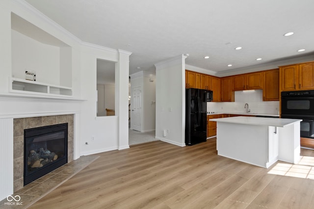 kitchen featuring recessed lighting, light countertops, light wood-style floors, and black appliances