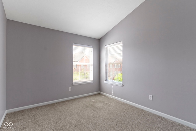 empty room with baseboards, light colored carpet, and lofted ceiling