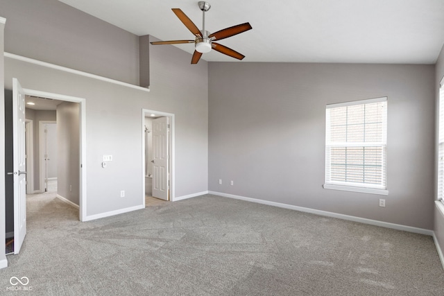 unfurnished bedroom featuring a ceiling fan, a towering ceiling, carpet floors, baseboards, and ensuite bath
