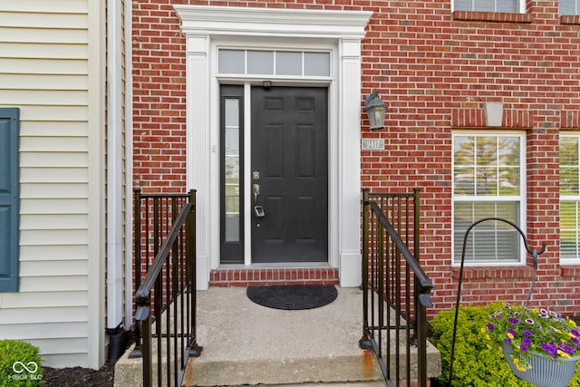 doorway to property featuring brick siding
