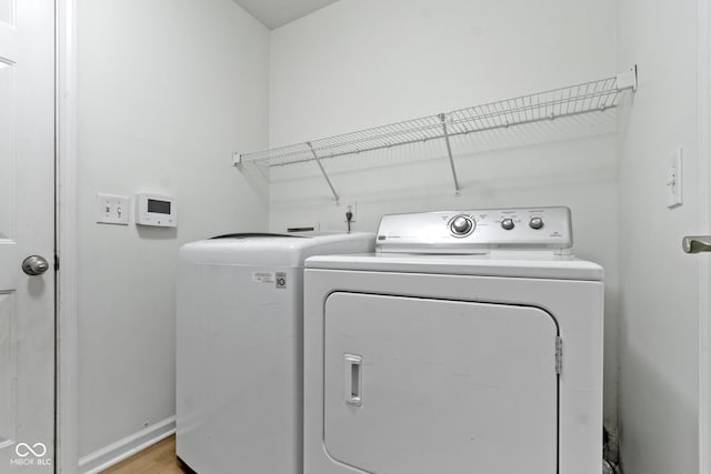 laundry room with laundry area, light wood-style flooring, baseboards, and independent washer and dryer