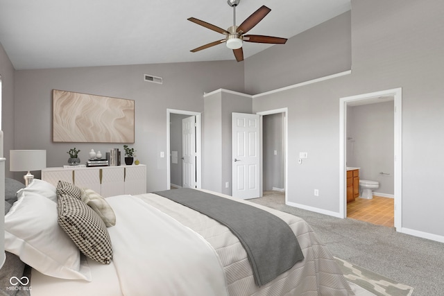 bedroom featuring light colored carpet, high vaulted ceiling, baseboards, ensuite bathroom, and visible vents