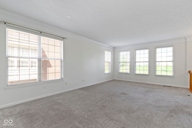unfurnished room featuring carpet floors, ornamental molding, and baseboards