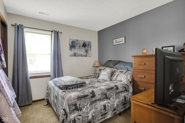 bedroom with visible vents, multiple windows, and light carpet
