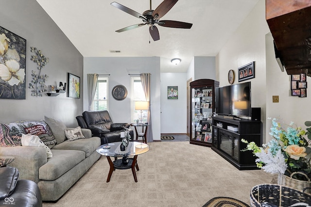 living area with a ceiling fan, visible vents, baseboards, lofted ceiling, and carpet