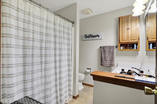 bathroom with toilet, a shower with curtain, baseboards, and vanity