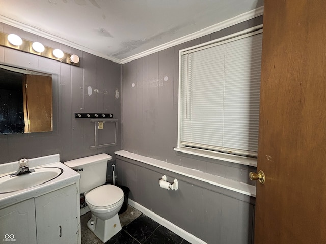 half bathroom featuring vanity, ornamental molding, and toilet