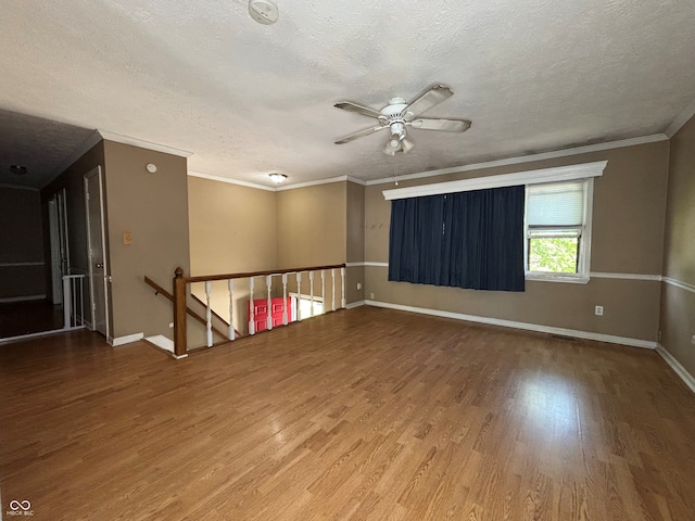 spare room with baseboards, a textured ceiling, ceiling fan, and wood finished floors