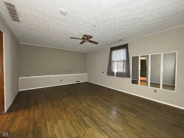 spare room featuring ceiling fan, a textured ceiling, visible vents, wood finished floors, and baseboards