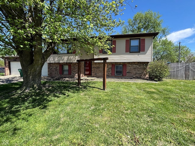split foyer home with fence, a garage, a front lawn, and brick siding