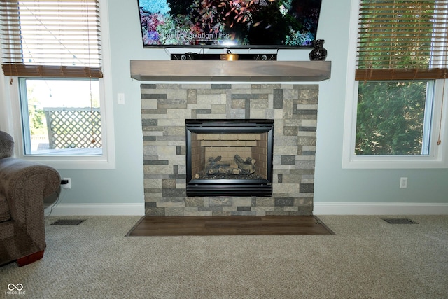 room details with a stone fireplace, baseboards, carpet floors, and visible vents