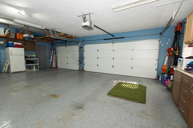 garage with a garage door opener and freestanding refrigerator