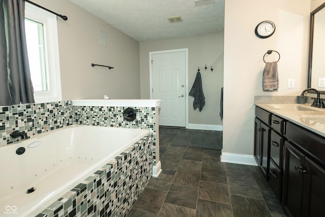 full bathroom with vanity, stone finish floor, a whirlpool tub, baseboards, and visible vents