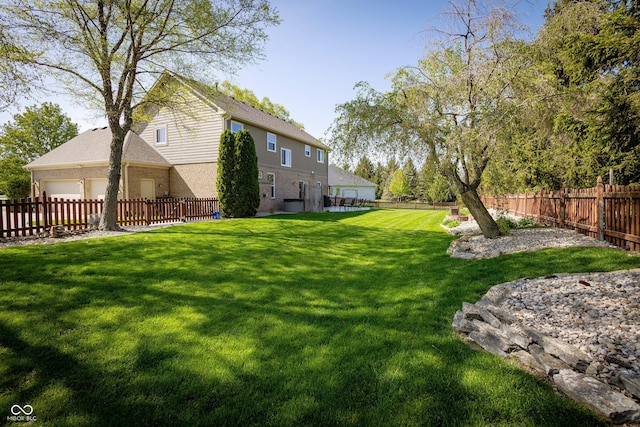 view of yard featuring a fenced backyard and a garage