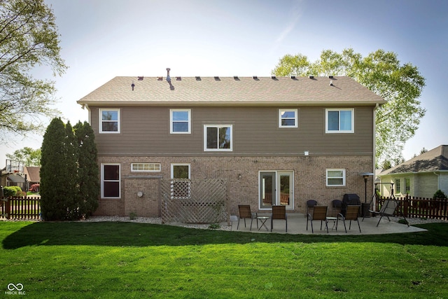 rear view of house featuring fence, a patio, and a lawn