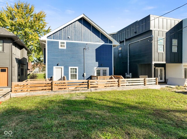 1417 E Michigan St, Indianapolis, IN 46201 - back of property featuring a lawn, fence, and board and batten siding