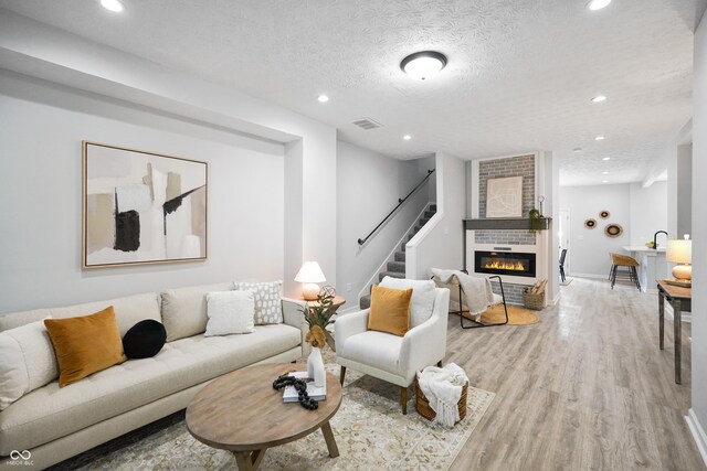 1417 E Michigan St, Indianapolis, IN 46201 - living area with light wood-style floors, a large fireplace, recessed lighting, visible vents, and stairway