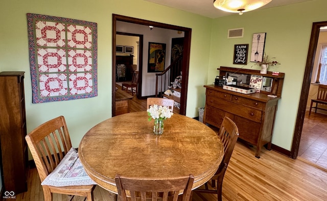 2405 Sycamore St, Columbus, IN 47201 - dining area featuring light wood-style floors, baseboards, and stairs