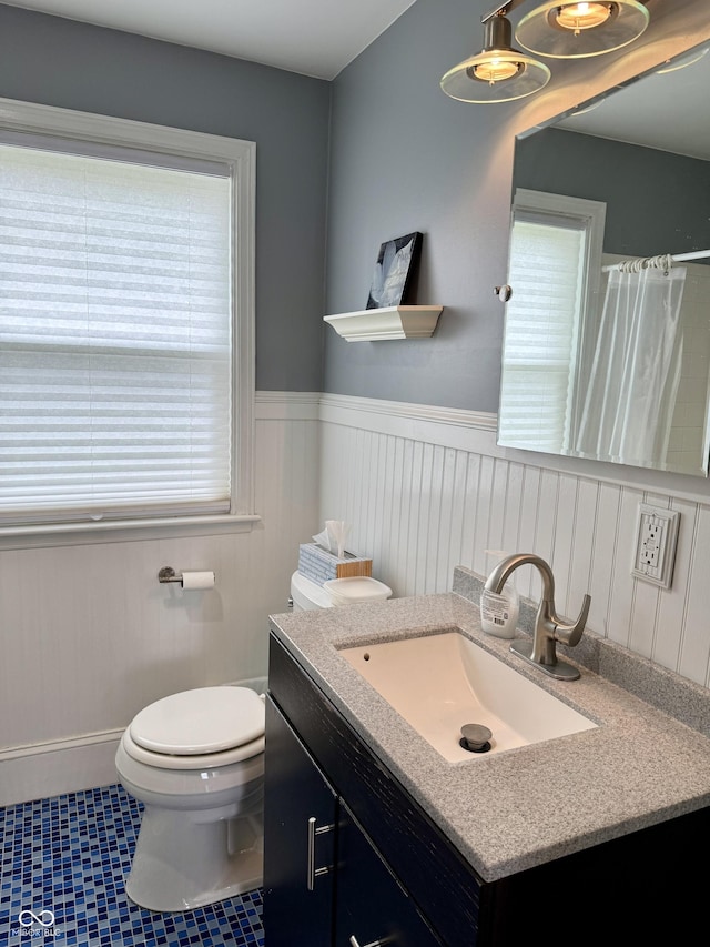 2405 Sycamore St, Columbus, IN 47201 - bathroom with vanity, a wainscoted wall, toilet, and a shower with shower curtain