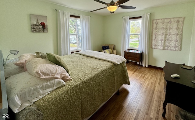 2405 Sycamore St, Columbus, IN 47201 - bedroom with multiple windows, wood finished floors, baseboards, and a ceiling fan