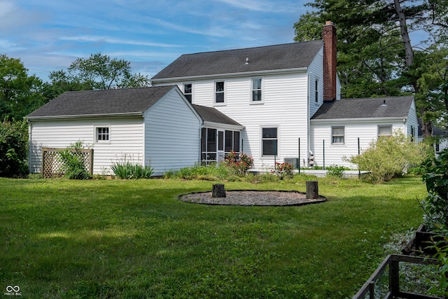 2405 Sycamore St, Columbus, IN 47201 - rear view of house featuring a chimney, a lawn, a shingled roof, and a sunroom