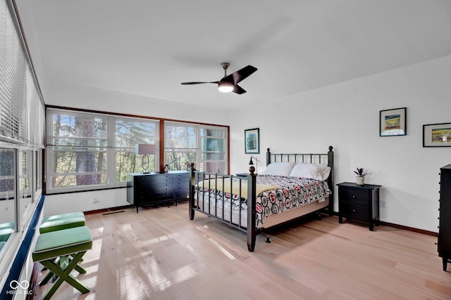bedroom with baseboards, ceiling fan, and light wood-type flooring