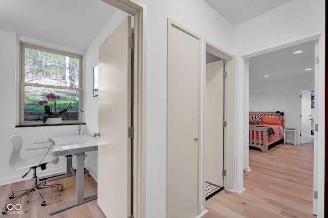 hall with light wood-style floors and recessed lighting
